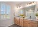A bathroom vanity features double sinks, granite counters, and views from the window at 10610 Reunion Pkwy, Commerce City, CO 80022