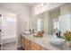 Bathroom with double sink vanity, large mirror, and decorative flowers at 10610 Reunion Pkwy, Commerce City, CO 80022