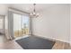 A sunny dining area features wood floors, a modern light fixture, and sliding glass doors to the outside at 10610 Reunion Pkwy, Commerce City, CO 80022