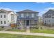 Two-story home with a covered porch and a well-maintained lawn and landscaping at 10610 Reunion Pkwy, Commerce City, CO 80022