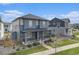 Two-story home features a welcoming front porch, manicured lawn, and complementing landscaping, enhancing its curb appeal at 10610 Reunion Pkwy, Commerce City, CO 80022