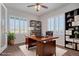 A stylish home office featuring hardwood floors, natural light, white plantation shutters and modern shelving at 10610 Reunion Pkwy, Commerce City, CO 80022