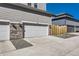 Home's garage with decorative gravel, white garage door, and wooden fence at 745 N Tempe St, Aurora, CO 80018