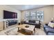 Cozy living room featuring a fireplace, stylish furnishings, and ample natural light streaming through large windows at 745 N Tempe St, Aurora, CO 80018