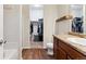 Well-lit bathroom featuring dual sinks, wood-look floors, and an adjacent walk-in closet at 9533 Cherry Ln, Thornton, CO 80229