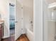 Bright bathroom features a separate tub and shower, wood-look floors, and bedroom view at 9533 Cherry Ln, Thornton, CO 80229