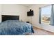 Cozy bedroom features a large bed, mounted TV, and sunny window at 9533 Cherry Ln, Thornton, CO 80229