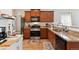 Kitchen featuring wood cabinets, granite counters, and stainless steel appliances at 9533 Cherry Ln, Thornton, CO 80229