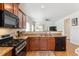 Kitchen with wood cabinets, granite counters, and stainless steel appliances at 9533 Cherry Ln, Thornton, CO 80229