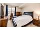 Well-lit bedroom with a dark wood furniture, plush carpeting, and a large window with blinds at 12820 Ironstone Way # 103, Parker, CO 80134
