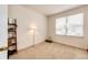 Well lit carpeted bedroom with a lamp, shelving, and large window at 12820 Ironstone Way # 103, Parker, CO 80134