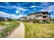 Scenic shot of condo complex with a walking path, lush greenery, and clear blue sky at 12820 Ironstone Way # 103, Parker, CO 80134