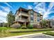 Attractive exterior view of multi-story condo complex with manicured landscaping, lawn and blue skies at 12820 Ironstone Way # 103, Parker, CO 80134