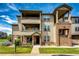 Stunning exterior shot of the multi-story condo building with inviting entrance and well-kept landscaping at 12820 Ironstone Way # 103, Parker, CO 80134