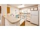 Functional kitchen with white appliances, neutral countertops, and ample cabinet space at 12820 Ironstone Way # 103, Parker, CO 80134