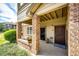 Cozy covered patio with brick columns, seating area, and a view of the surrounding greenery at 12820 Ironstone Way # 103, Parker, CO 80134