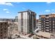 An exterior, high-angle view of the condo building against a mountain backdrop and street-level parking at 2 Adams St # 806, Denver, CO 80206