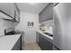 Bright kitchen features stainless steel appliances, sleek countertops, and stylish dark cabinetry at 2 Adams St # 806, Denver, CO 80206