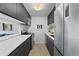 Modern kitchen with sleek, dark cabinetry, stainless steel appliances, and white countertops at 2 Adams St # 806, Denver, CO 80206