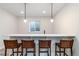 Modern basement bar area featuring a quartz countertop, seating for four, and stylish pendant lighting at 1581 Diamond Hill Ct, Castle Rock, CO 80104