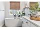 Bright bathroom with a soaking tub, woven window shade, and a white vanity to create a spa-like experience at 1581 Diamond Hill Ct, Castle Rock, CO 80104
