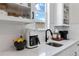 Chic kitchen featuring sleek countertops, white cabinets, stainless sink, and modern appliances at 1581 Diamond Hill Ct, Castle Rock, CO 80104