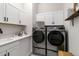 Well-lit laundry room featuring a stacked washer/dryer and ample cabinet space for convenient storage at 1581 Diamond Hill Ct, Castle Rock, CO 80104