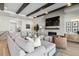 Spacious living area featuring exposed ceiling beams, a fireplace, and a cozy sectional for relaxation at 1581 Diamond Hill Ct, Castle Rock, CO 80104