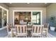 Covered patio featuring an outdoor dining table, with view into the living spaces and an enclosed lawn at 1581 Diamond Hill Ct, Castle Rock, CO 80104