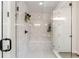 Modern shower with white tiles, a built-in seat, and sleek glass door with black trim at 1581 Diamond Hill Ct, Castle Rock, CO 80104