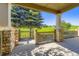 Covered back porch with stone columns overlooking a lush green space, providing a serene outdoor retreat at 23738 E Clifton Pl, Aurora, CO 80016