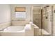 Bathroom featuring a soaking tub, glass block window, and tiled shower at 23738 E Clifton Pl, Aurora, CO 80016