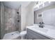 Bathroom features a shower with gray tile surround, gray vanity, and modern fixtures at 4064 S Olathe Ct, Aurora, CO 80013