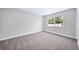 A bright bedroom features a large window and neutral carpeting at 4064 S Olathe Ct, Aurora, CO 80013