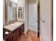 Well-lit bathroom with a vanity sink, mirror, and wood floors at 1050 S Monaco Pkwy # 38, Denver, CO 80224