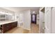 Well-lit bathroom with wood vanity, walk-in closet, and updated fixtures at 1050 S Monaco Pkwy # 38, Denver, CO 80224