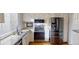 Bright kitchen features white cabinets, granite countertops, stainless steel appliances, and hardwood floors at 1050 S Monaco Pkwy # 38, Denver, CO 80224