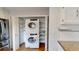 Conveniently located laundry closet with stacked washer and dryer units and shelving for storage at 1050 S Monaco Pkwy # 38, Denver, CO 80224