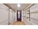 Spacious walk-in closet featuring built-in shelving and wood flooring at 1050 S Monaco Pkwy # 38, Denver, CO 80224