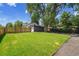 Large green backyard with wooden fence, big trees, and RV or Boat parking spots at 8801 E 16 Ave, Denver, CO 80220