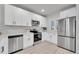 Modern kitchen with white cabinets, stainless steel appliances, and sleek countertops for a clean look at 8801 E 16 Ave, Denver, CO 80220