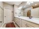 Bathroom features double sinks, a large mirror, and white cabinets at 19688 E 52Nd Ave, Denver, CO 80249