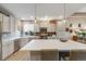 Bright kitchen features a large island, stainless steel appliances, and stylish gray cabinets and backsplash at 19688 E 52Nd Ave, Denver, CO 80249
