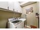 Well-equipped laundry room with modern washer, dryer, and ample overhead cabinet space, perfect for efficient home management at 19688 E 52Nd Ave, Denver, CO 80249