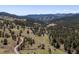 Expansive landscape featuring rolling hills, mature trees, and country road at 2571 Sw Grapevine Rd, Idledale, CO 80453