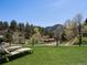 Spacious backyard with green lawn and mountain backdrop perfect for outdoor activities at 2571 Sw Grapevine Rd, Idledale, CO 80453