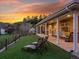 Backyard featuring green lawn, a covered patio with seating, and scenic views of the surrounding landscape at sunset at 2571 Sw Grapevine Rd, Idledale, CO 80453