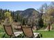 Relaxing backyard view with lounge chairs overlooking the lush greenery and mountain scenery at 2571 Sw Grapevine Rd, Idledale, CO 80453