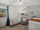 Stylish Bedroom with soothing colors, patterned wallpaper, crib, and a comfy chair at 2571 Sw Grapevine Rd, Idledale, CO 80453