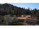 Gorgeous exterior shot of home at dusk featuring well-maintained lawns and mountain views at 2571 Sw Grapevine Rd, Idledale, CO 80453
